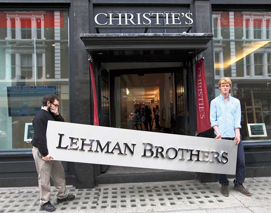 এক সময়ে নামী ইনভেস্টমেন্ট ব্যাঙ্ক লেম্যান ব্রাদার্সয়ে কাজের সুযোগ পেলে কদর বেড়ে যেত। দেউলিয়া ঘোষণার প্রায় দু’বছর পরে সেই লেম্যানের কর্মীরাই লন্ডনে নিলাম সংস্থা ক্রিস্টি’জ-এর সামনে প্রতীকী প্রতিবাদে। হাতে ব্যাঙ্কের ‘সাইনবোর্ড’।