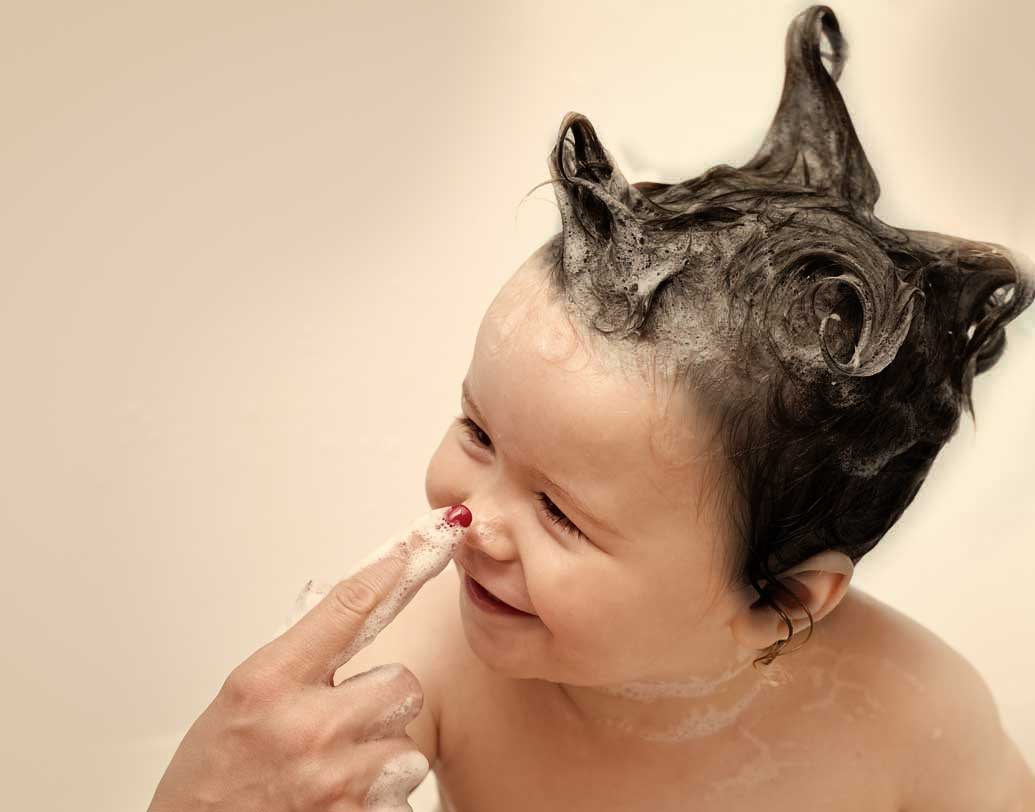 নিয়ম করে মাথায় শ্যাম্পু করান। অনেক অভিভাবকই ঠান্ডা লাগার ভয়ে ছোট শিশুদের খুব একটা নিয়ম মেনে শ্যম্পু করান না। এতে চুলের সঙ্গে মাথার ত্বকেরও ক্ষতি হয়। ঠান্ডার ভয় থাকলে উষ্ণ জলে হালকা করে শ্যাম্পু করান। ভাল করে চুল শুকিয়ে তবেই পাখার তলায় আনুন। গরম জলেই গা স্পঞ্জ করিয়ে দিন সে দিন। ছবি: শাটারস্টক।