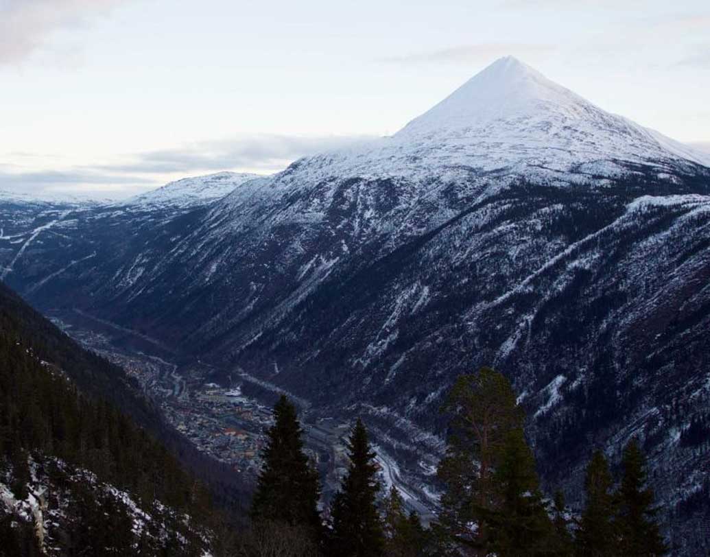 এমনিতেই প্রাকৃতিক অবস্থানের জন্য গোটা দেশেই সূর্যের আলো কম ঢোকে। উপত্যকা-শহর জুকনের আবার চার দিক পাহাড়ে ঘেরা। ফলে শীতকালে যেটুকু আলো বরাদ্দ ছিল, বিশাল বিশাল পাহাড়ে ধাক্কা খেয়ে তা আটকে যেত পাহাড়ের শীর্ষেই।