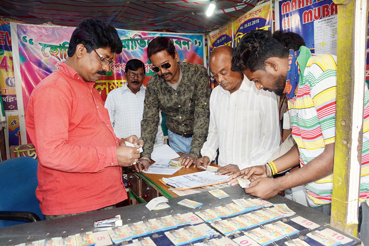 লটারির টিকিটের নম্বর মেলানোর ভিড়। উলুবেড়িয়ায়। ছবি: সুব্রত জানা