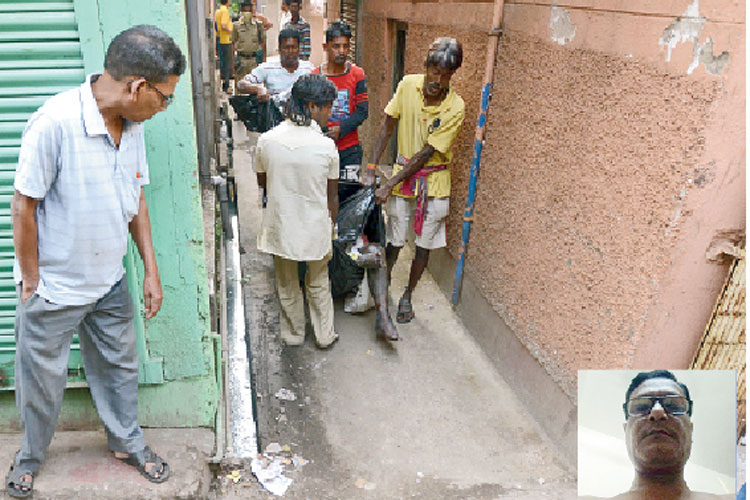 হাওড়ার ফ্ল্যাট থেকে বার করা হচ্ছে অমিত মুন্সির (ইনসেটে) দেহ। মঙ্গলবার। —নিজস্ব চিত্র।