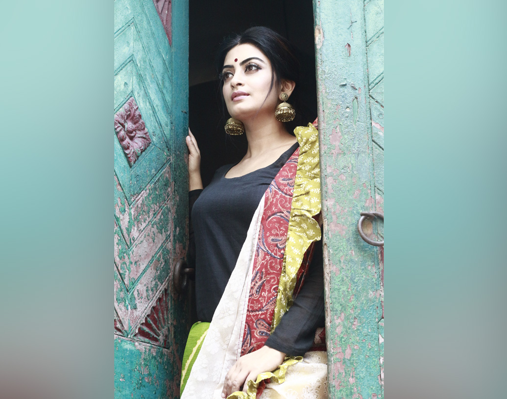 অঙ্কিতা শাড়িই পরেছেন। তবে সঙ্গে কালো টপ, শাড়িটিও একেবারে অন্যরকম ভাবে পরেছেন তিনি। বড় কালো টিপের সঙ্গে ভারী ঝুমকো বেছে নিয়েছেন অভিনেত্রী।