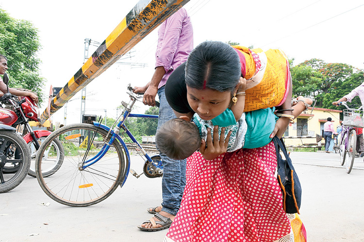 ঝুঁকি নিয়ে চলছে পারাপার। বেলডাঙা পাঁচরাহা রেলগেটে। রবিবার।  নিজস্ব চিত্র