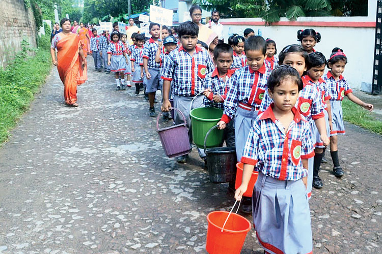 প্রচার: বালতি হাতে মিছিলে স্কুলপড়ুয়ারা। বুধবার, নরেন্দ্রপুরে। নিজস্ব চিত্র