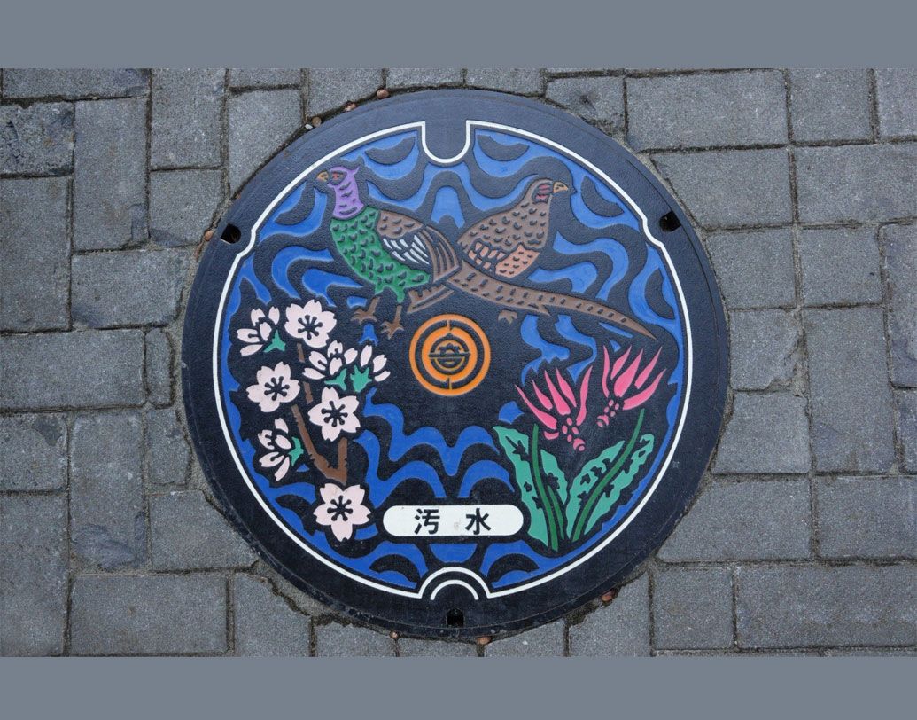 দেওয়াল বা ঘরবাড়ি ছাড়িয়ে এ বার জাপানের রাস্তায় ম্যানহোলের ঢাকনাগুলিও নজর কাড়ছে উৎসাহীদের। ম্যানহোলে আঁকা বহুমুখী শিল্পকর্ম দেখতে সুদূর প্রান্ত থেকেও অনেকে ভিড় জমাচ্ছেন জাপানের বিভিন্ন শহরে।