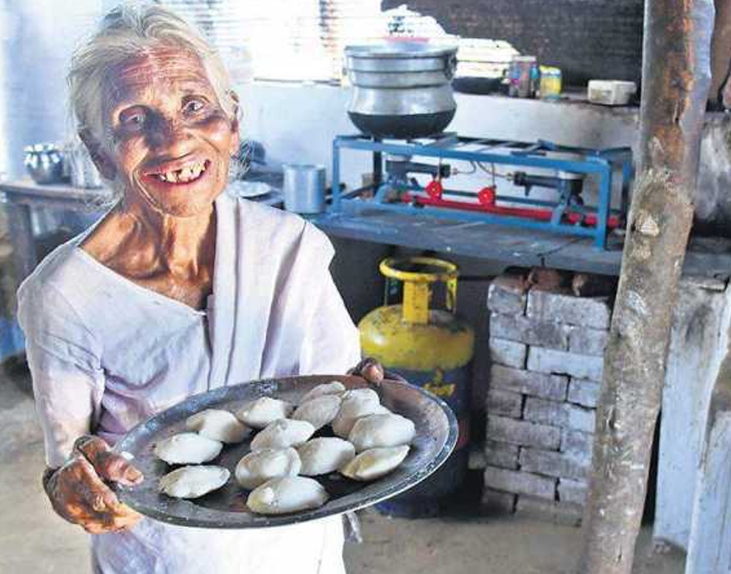 কেন গ্যাস ব্যবহার করেন না? বৃদ্ধা বলেছেন, তিনি জানেনই না কী করে গ্যাসে রান্না করতে হয়। মাটির উনুনেই তিনি স্বচ্ছন্দ। রোজ আট কেজি চাল শিলনোড়ায় বেঁটে বা জাঁতায় পিষে তিনি বানান কয়েকশো ইডলি।