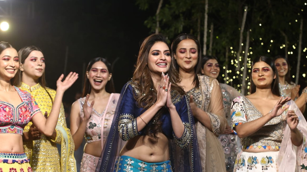 কলকাতার পাঁচতারা হোটেলের ছন্দে তখন বেজে উঠেছে ‘দেশি গার্ল’। একদল ঝলমলে সুন্দরীর মাঝ থেকে বেরিয়ে এলেন নুসরত জাহান। নমস্কারে হাসিতে, খোলা চুলে, চোলি আর ঘাগরাতে রাত গভীর করলেন।