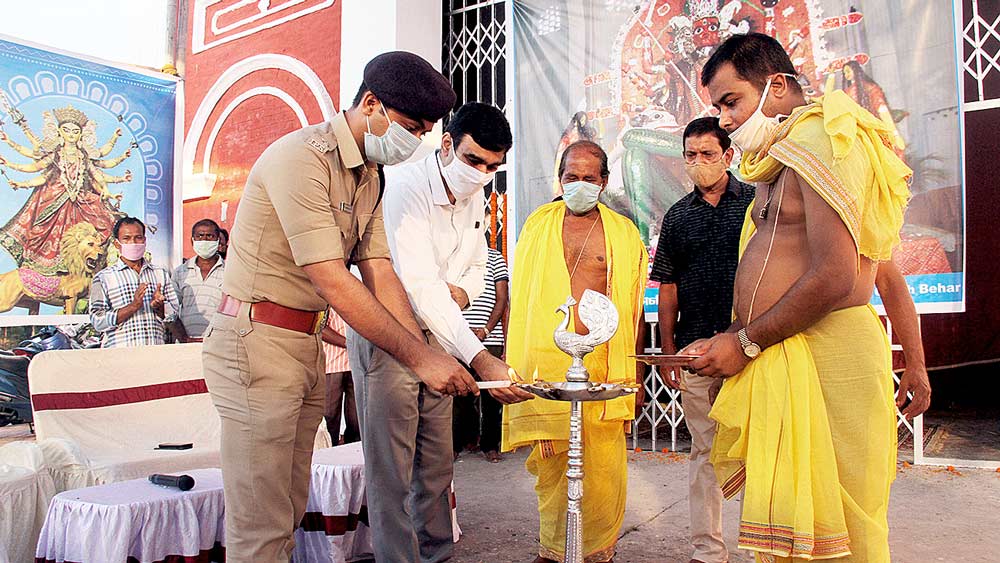 সূচনা: বড়দেবীর পুজোর উদ্বোধনের পরে প্রদীপ জ্বালাচ্ছেন জেলাশাসক পবন কাদিয়ান। নিজস্ব চিত্র।