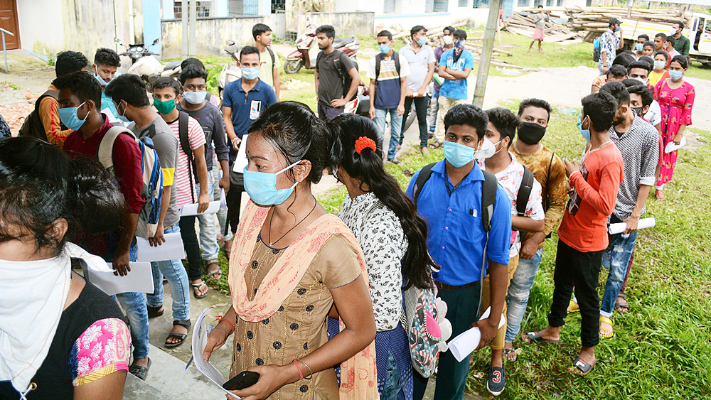 সরণিতে: অনলাইনে সমস্যার জেরে বৃহস্পতিবার আলিপুরদুয়ার কলেজে পরীক্ষার খাতা  জমা দিতে পড়ুয়াদের। নিজস্ব চিত্র।