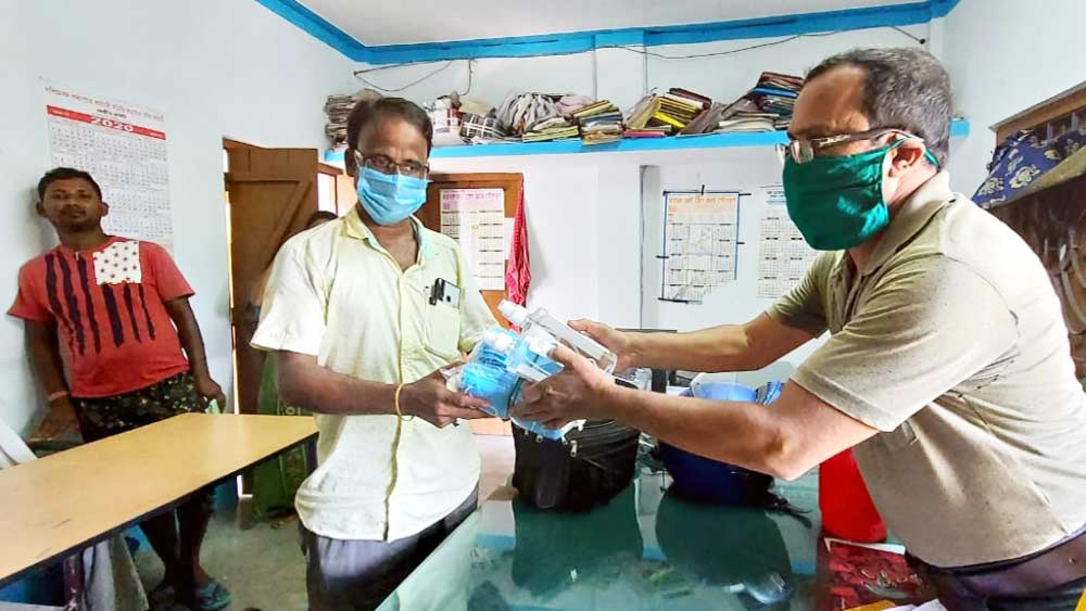 প্রস্তুতি: পুজোকর্তাদের হাতে তুলে দেওয়া হচ্ছে মাস্ক ও স্যানিটাইজ়ার। মঙ্গলবার দিনহাটা থানায়। নিজস্ব চিত্র।