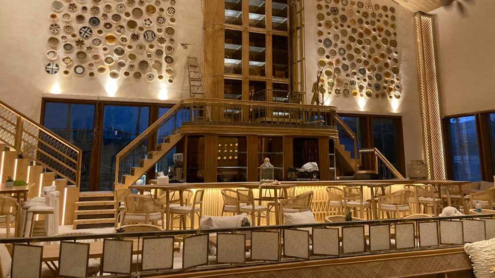 সোশ্যাল মিডিয়ায় শেয়ার করা ছবি দেখেই বোঝা যাচ্ছে ‘ব্যাস্টিয়ান’-এর অন্দরসজ্জার বিশেষত্ব। ভল্টেড সিলিং থেকে অনেক দূর নেমে আসা ফ্যান বা আসবাবপত্র। সবকিছুই সাজানো সাদা এবং বেজ রঙের কম্বিনেশনে।