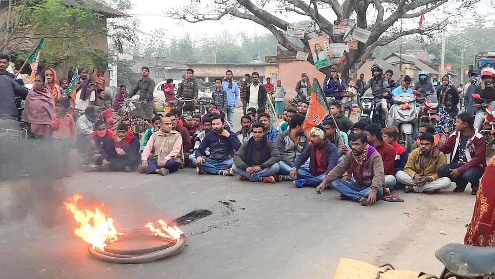 ক্ষোভ: পাত্রসায়রের হলুদবনি মোড়ে টায়ার জ্বালিয়ে রাস্তায় বসে পড়েছেন বিজেপি কর্মীরা। নিজস্ব চিত্র।