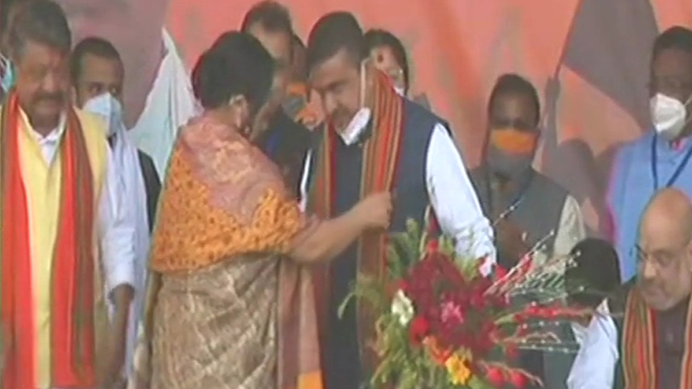 মঞ্চে ওঠার পরে শুভেন্দু অধিকারীকে পুষ্পস্তবক দিয়ে বরণ করে নেন কেন্দ্রীয় প্রতিমন্ত্রী দেবশ্রী চৌধুরী।