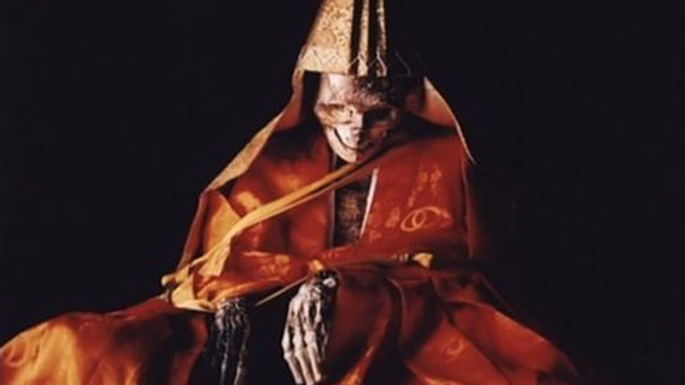 ওই কক্ষে সন্ন্যাসীর সঙ্গে শুধু একটা ঘণ্টা থাকত। প্রতিদিন তিনি ঘণ্টা বাজিয়ে বোঝাতেন যে, তিনি বেঁচে আছেন। যে দিন তিনি ঘণ্টা আর বাজাবেন না, সে দিনই ধরে নেওয়া হত তিনি মারা গিয়েছেন। তার পর বাঁশের ফানেলটা খুলে নেওয়া হত।