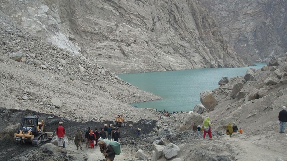 এই জায়গাতেই ছিল হুনজা গ্রাম। পাহাড়ি পথ বেয়ে স্কুলে পড়তে যেত ছোট ছেলেমেয়েরা। কারাকোরাম পর্বতের নীচ দিয়ে গাড়ি ছুটত সড়ক ধরে। আর এই গ্রামের পাশ দিয়ে বয়ে যেত খরস্রোতা হুনজা নদী।