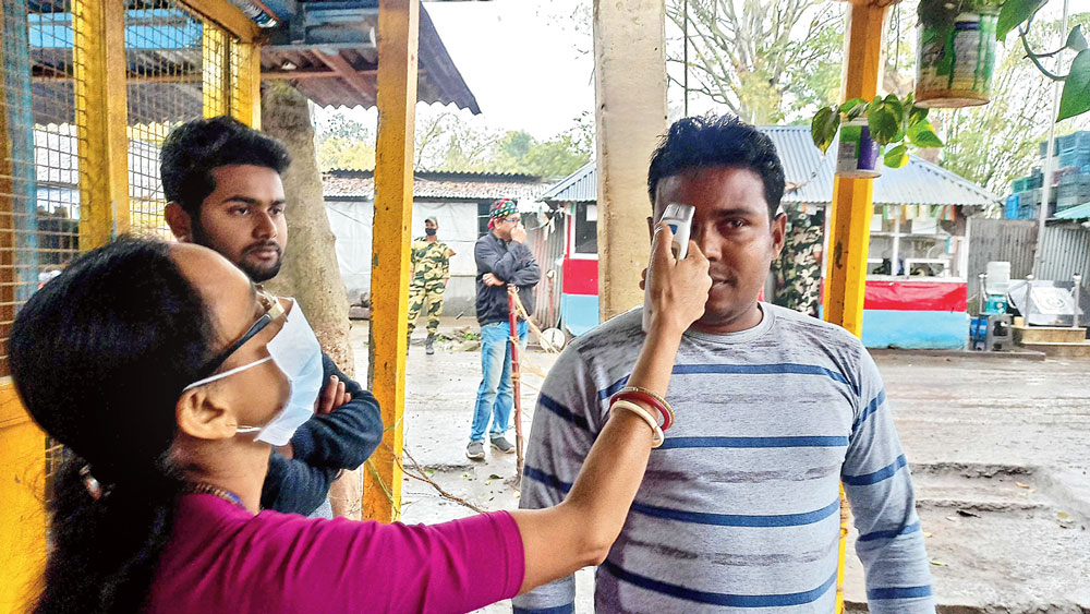 প্রতিরোধ: জ্বরের চিহ্ন খুঁজতে ভরসা যন্ত্র। তা নিয়েই পরীক্ষা স্বাস্থ্যকর্মীদের। শনিবার হিলি সীমান্তে। ছবি: অমিত মোহান্ত