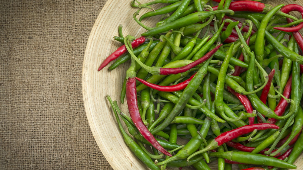 কাঁচা লঙ্কা: বায়ুরুদ্ধ কোনও ঢাকা পাত্র থাকলে তাতে রাখুন কাঁচা লঙ্কা। রাখার আগে পাত্রের নীচে হালকা নরম কাপড় বিছিয়ে দেবেন। লঙ্কার বৃন্ত ছিঁড়ে রাখুন। এতে লঙ্কা সহজে পচে না। এ বার মুখ বন্ধ পাত্রটি অন্য আর একটি নরম কাপড়ে ঢেকে নিন। বাড়ি থেকে দীর্ঘ দিনের জন্য কোথাও বেড়াতে গেলেও এই ভাবে রেখে যেতে পারেন কাঁচালঙ্কা। এর পর এই পাত্র ফ্রিজে ঢুকিয়ে রাখতেও পারেন। আরও ভাল ফল পেতে অ্যালুমিনিয়াম ফয়েল পেঁচিয়ে রাখুন লঙ্কা।