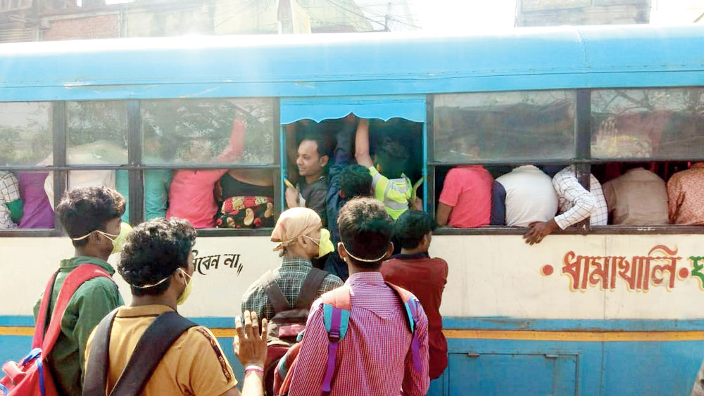 Coronavirus in India: Overcrowded bus passengers on their way to office