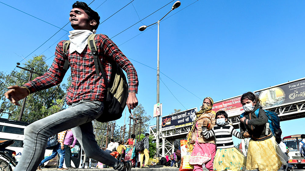 মরিয়া: গত ২৪ মার্চ মধ্যরাত থেকে দেশ জুড়ে লকডাউন ঘোষণা করেছিলেন প্রধানমন্ত্রী। তার কয়েক দিন পরেই গ্রামের বাড়ি ফেরার বাস ধরতে দৌড় এক পরিযায়ী শ্রমিক পরিবারের। উত্তরপ্রদেশের গাজিয়াবাদে। ছবি: পিটিআই