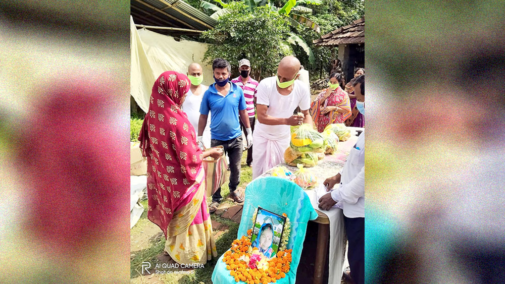 দুঃস্থদের হাতে ত্রাণ তুলে দিচ্ছেন বৃদ্ধার ছেলে। —নিজস্ব চিত্র