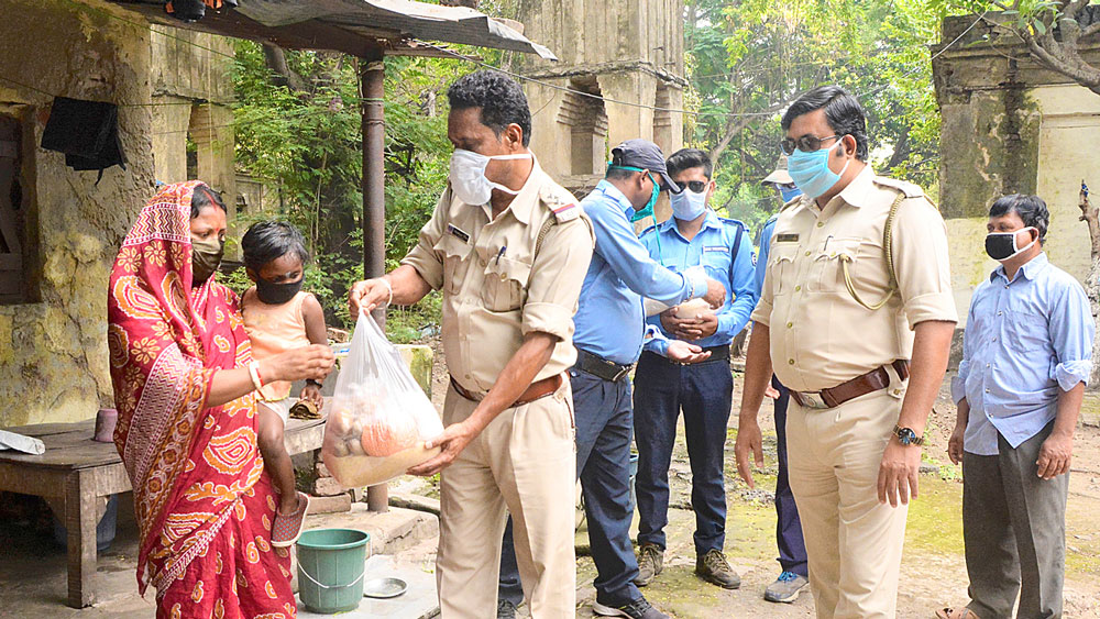 দুঃস্থদের হাতে খাদ্যসামগ্রী তুলে দিচ্ছে পুলিশ। কুলটিতে। নিজস্ব চিত্র