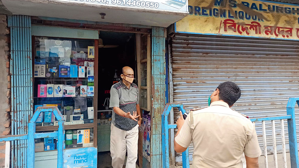 তরজা: ব্যবসায়ীকে দোকান বন্ধ করতে নির্দেশ পুলিশের। বালুরঘাটে। ছবি: অমিত মোহান্ত