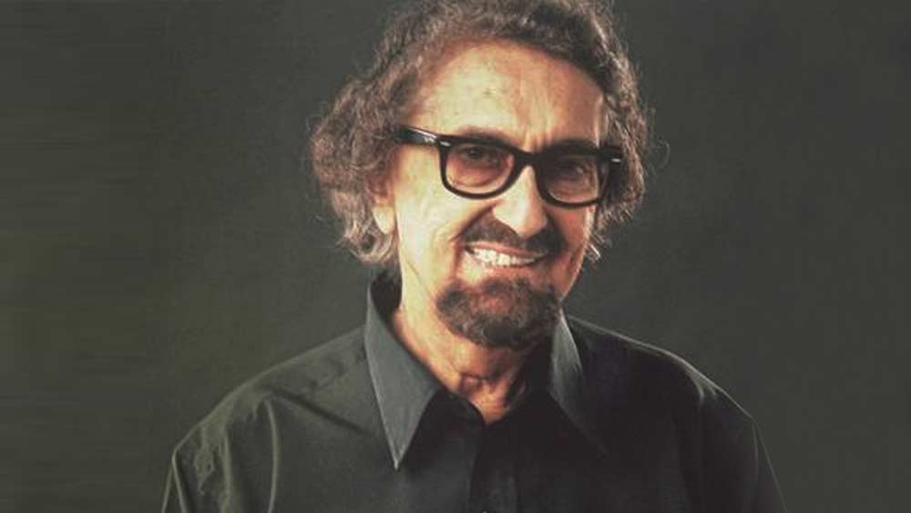 গুজরাতের কচ্ছ প্রদেশে তাঁর জন্ম ১৯২৮ সালের ৫ মার্চ। অতীতে পারিবারিক পেশা চারণগান ছিল। তাই তাঁদের পদবি ছিল ‘চারণিয়া’। পরে অ্যালেকের ঠাকুরদার সময় থেকে পরিচয়ে যুক্ত হয় নতুন উপাধি।