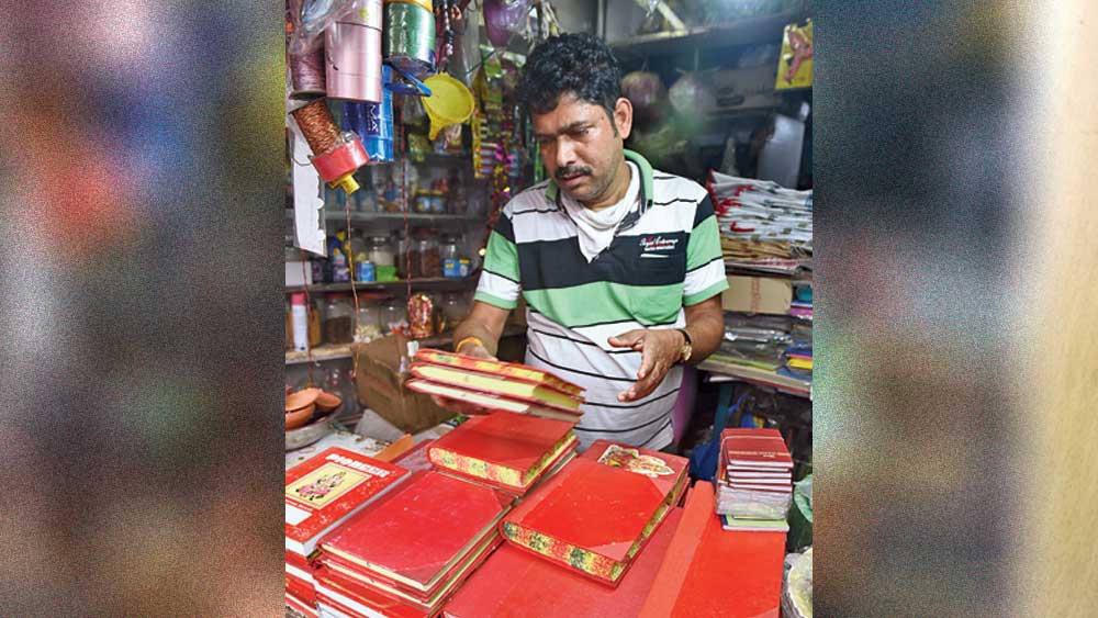 নতুন খাতা সাজিয়ে রাখছেন এক বিক্রেতা। বৌবাজারে। নিজস্ব চিত্র