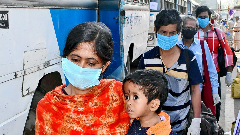 শ্রান্ত: বাঁকুড়া স্টেশনে নামার পরে বাস ধরতে যাওয়া পরিযায়ী শ্রমিক ও অসুস্থেরা। ছবি: অভিজিৎ সিংহ