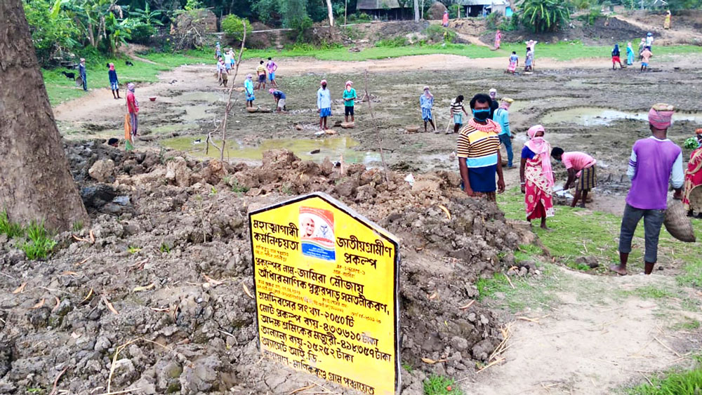 নিয়মমতে: সামাজিক দূরত্ব বিধি মেনে, মাস্ক পরে চলছে একশো দিনের প্রকল্পে পুকুর পাড় সমতল করার কাজ। চন্দ্রকোনা ১ ব্লকের জামিরা গ্রামে। নিজস্ব চিত্র