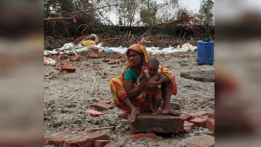 কুলতলির আর এক প্রান্তে সন্তানকে কোলে নিয়ে আশ্রয়ের খোঁজে অসহায় মা।