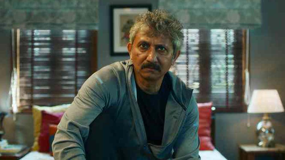 নীরজ কবি। পাতাল লোক সিরিজে হুমকি পাওয়া সাংবাদিক সঞ্জীব মেহরার ভূমিকায় অভিনয় করেছেন ইনি। তাঁকে খুন করার হুমকি দিয়েই ঘনীভূত সিরিজের রহস্য। খুনের হুমকি পাওয়ার পর কেমন ছিল সঞ্জীব মেহরার জীবন? এই হুমকি তাঁর জীবনকে কী ভাবে পাল্টালো তা দেখাবে এই সিরিজ।