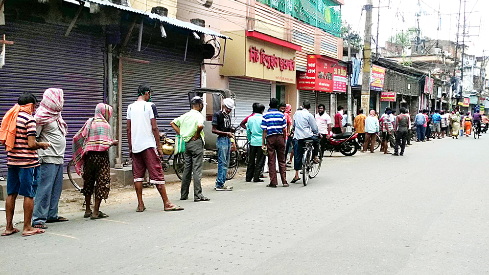 বর্ধমানের বিসি রোডে একটি মদের দোকানের সামনে লাইন। মঙ্গলবার দুপুরে। ছবি: উদিত সিংহ