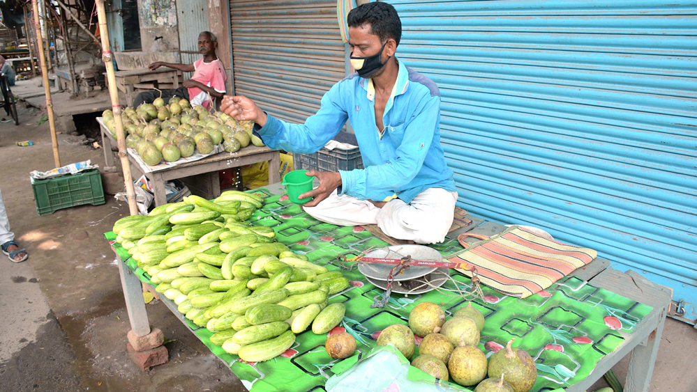 বদল: শসা, বেল বিক্রি করছেন সুদর্শন মহন্ত। নিজস্ব চিত্র