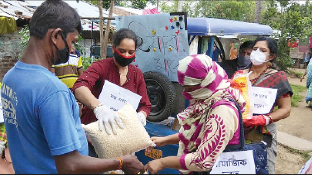 খাদ্যদ্রব্য বিলি করছেন ওই মহিলারা। নিজস্ব চিত্র

