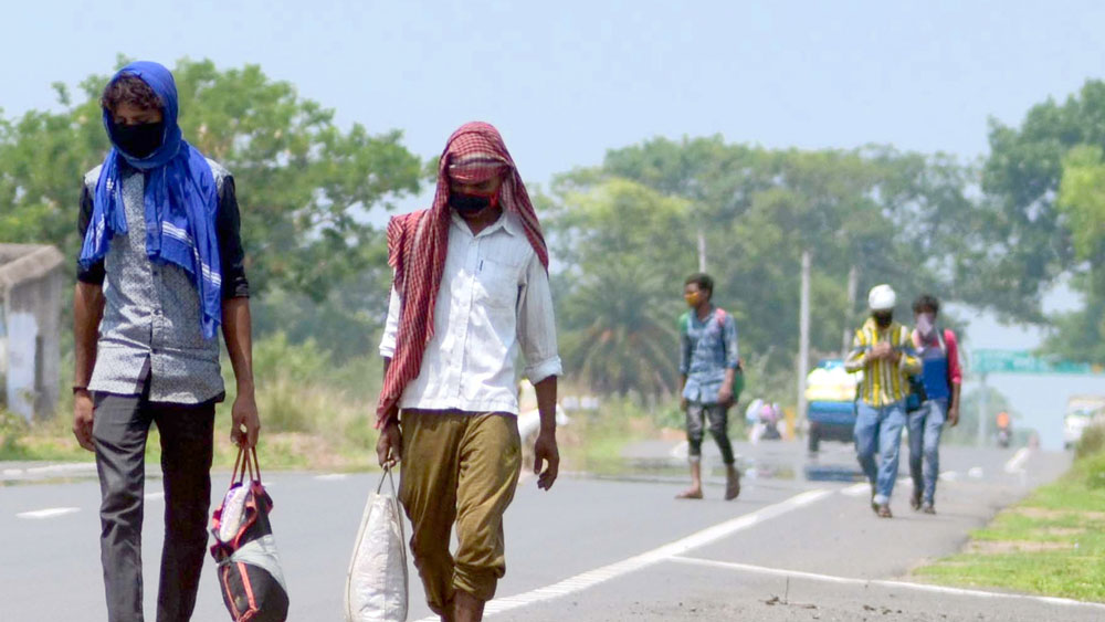 জাতীয় সড়ক ধরে হেঁটে ফিরছেন পরিযায়ী শ্রমিকরা। খয়রাশোলের পাইগড়ায়। ছবি: দয়াল সেনগুপ্ত