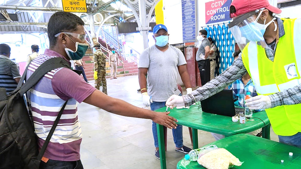 স্বাস্থ্য পরীক্ষার পরে হাতে দেওয়া হচ্ছে কালির দাগ। আদ্রা স্টেশনে সোমবার। নিজস্ব চিত্র 