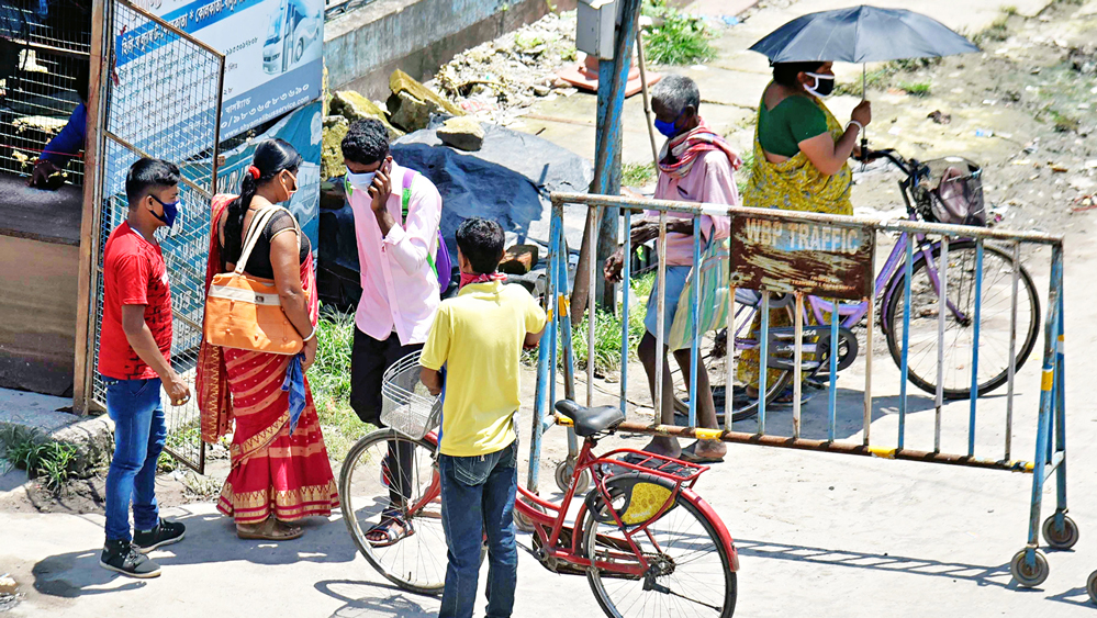 অমান্য: পুলিশের দেওয়া গার্ড ওয়াল পেরিয়েই অবাধে যাতায়াত বালুরঘাট বাস স্ট্যান্ড এলাকায়। ছবি: অমিত মোহান্ত