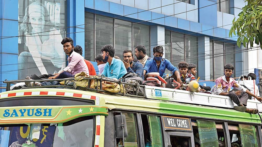  বিধিভঙ্গ: লকডাউনের আগে বহরমপুরের পথে যাত্রা বাসের ছাদে চড়েই। শুক্রবার, বারাসতে। ছবি: বিশ্বনাথ বণিক