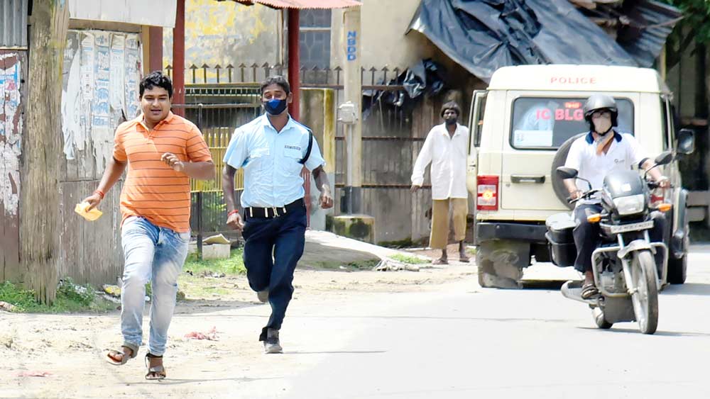  বিনা কারণে রাস্তায় বার হওয়া মাস্কহীন যুবককে ধাওয়া সিভিক পুলিশের। শনিবার বালুরঘাটে। ছবি: অমিত মোহান্ত