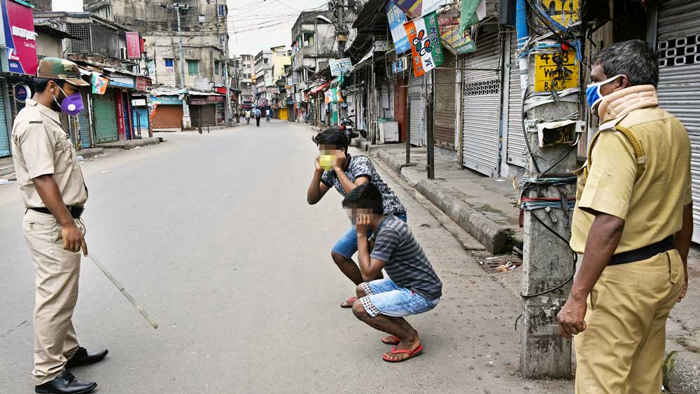 প্রয়োজন ছাড়াই বাইরে বেরোনোয় শাস্তির মুখে দুই যুবক। শনিবার, বাগুইআটি মেন রোডে। ছবি সুমন বল্লভ