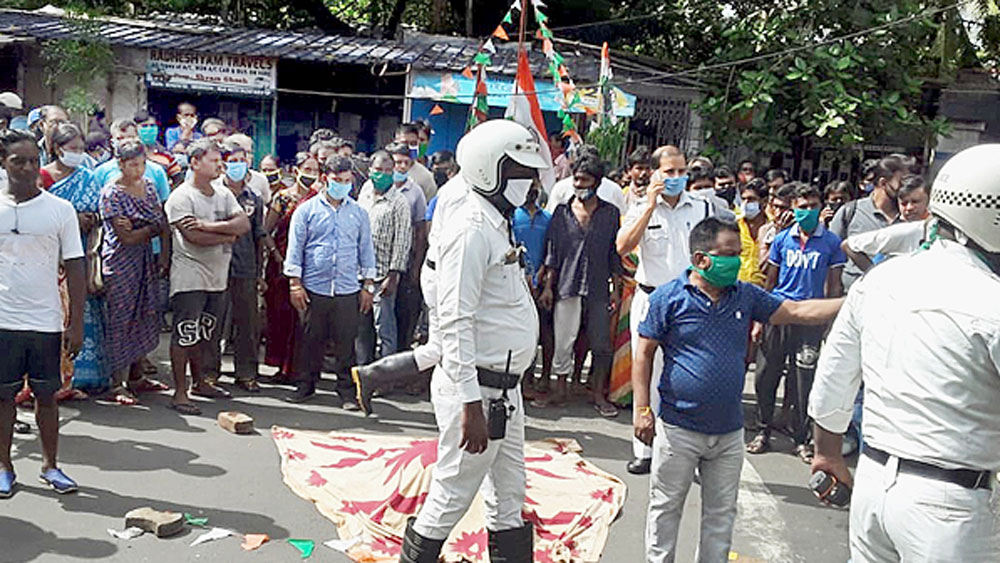 রাস্তায় তখনও পড়ে বৃদ্ধার দেহ, ঘটনাস্থলে পুলিশ। বুধবার, মুচিবাজারে। নিজস্ব চিত্র