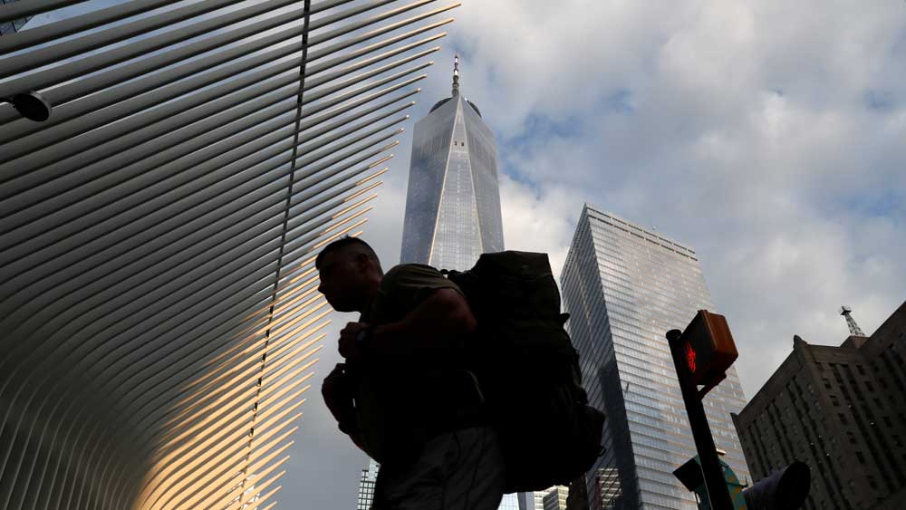 নবনির্মিত ওয়ার্ল্ড ট্রেড সেন্টারকে পটভূমিকায় রেখে সাবওয়ে স্টেশনে ঢুকছেন যাত্রী।