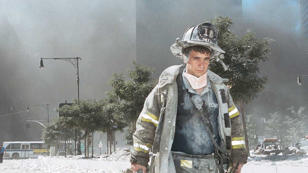 ধ্বস্ত দমকলকর্মী। সারা শরীর ঢাকা ছাইয়ে। ছবি: ফাইল ও রয়টার্স।