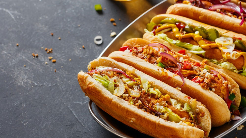 জার্মানিতে এক সময় যে হেতু সসেজের অন্য নাম ছিল ‘ডগ’ এবং এটি গরম গরম পরিবেশন করা হচ্ছিল তাই কার্টুনে এই খাবারকে তিনি ‘হট ডগ’ বলে উল্লেথ করেন তিনি। তখন থেকেই এই নামটি জনপ্রিয় হয়ে ওঠে।