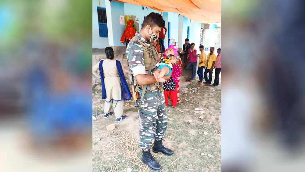 যত্ন: জওয়ানের কোলে শিশু।