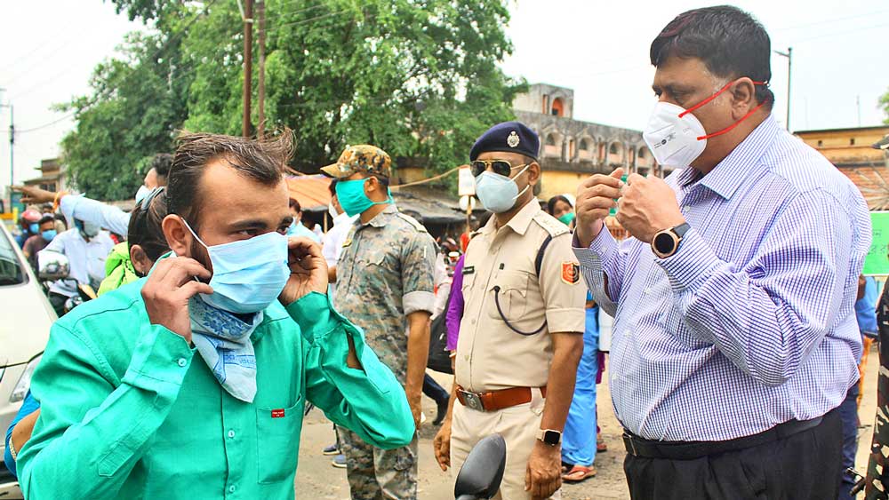  কড়া: মাস্ক পরার ব্যাপারে রাস্তায় নেমে সচেতন করছেন পুরুলিয়ার জেলাশাসক ও পুলিশ সুপার। শুক্রবার রঘুনাথপুরে। 