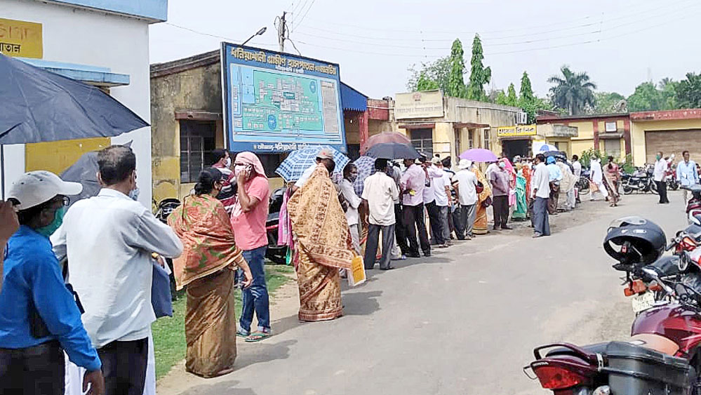 অপেক্ষা: কাঠফাটা রোদে ভ্যাকসিন নেওয়ার লাইন। ধনেখালি গ্রামীণ হাসপাতালে। নিজস্ব চিত্র