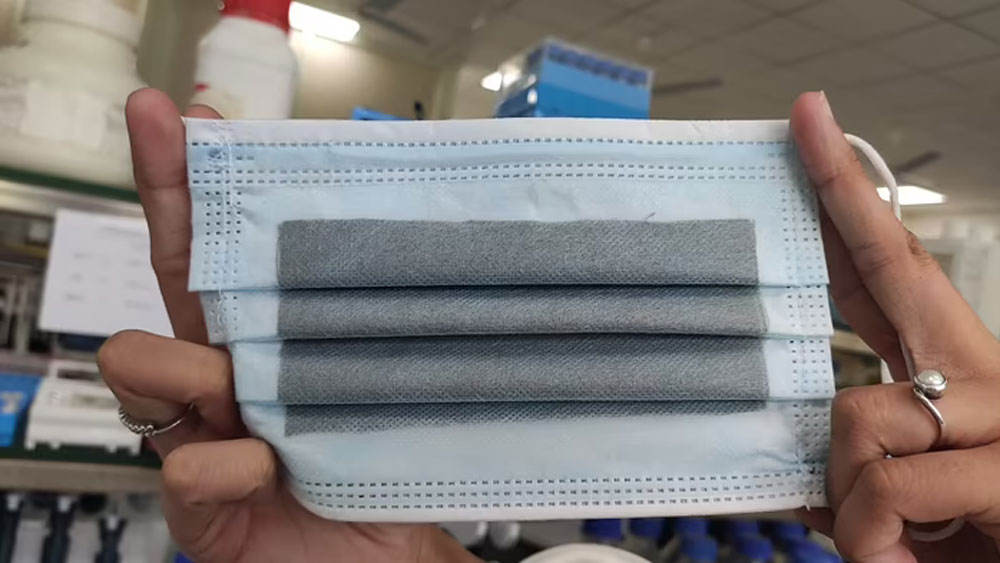 মলিবডেনাম ডাইসালফাইড। এই বিশেষ উপাদান দিয়ে একটি চুলের থেকেও কয়েক গুণ পাতলা একটি আস্তরণ তৈরি করা হয়েছে। যা মাস্কের উপরে লাগিয়ে দিচ্ছেন গবেষকরা।