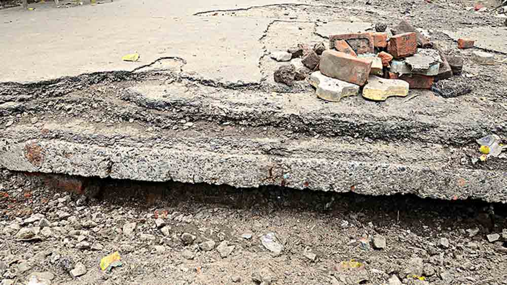 বেহাল: জমা জল সরতেই ধস নেমেছে রাস্তায়। সোমবার, ড্রেনেজ ক্যানাল রোডে। ছবি: দীপঙ্কর মজুমদার